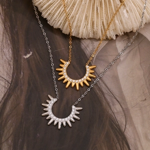 Close-up of U-shaped sunburst pendants with micro-pave crystals in gold and silver