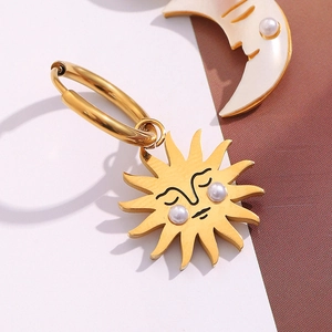 Detailed close-up of 18K gold-plated sun and moon earrings with pearl accents