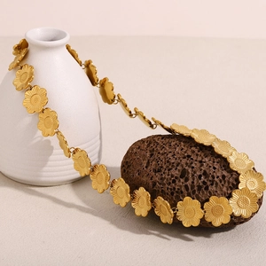Détail du collier à fleurs plaqué or 18 carats sur céramique et pierre blanche