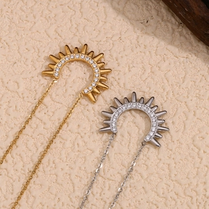 Detailed close-up of gold and silver sunburst pendants with micro-pave white zircon stones