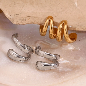 Macro shot of double-layer stainless steel ear cuffs in gold and silver with water drops