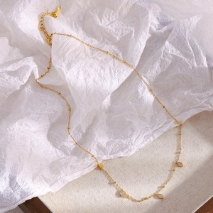 Nahaufnahme der 18K vergoldeten Perlenkette mit diamantbesetzten Rautenanhängern