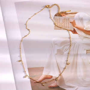 Detail einer 18K vergoldeten Perlenkette mit fünf Rautenanhängern auf einem Magazin