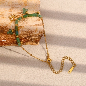 Dettaglio del bracciale placcato oro 18K con perline verdi e ciondolo a fiore su pietra