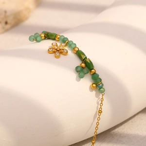 Dettaglio del bracciale a catena placcato oro 18K con perline verdi e ciondolo a fiore