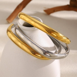 Bracelets polis plaqués or 18 carats et argent sur un support minimaliste