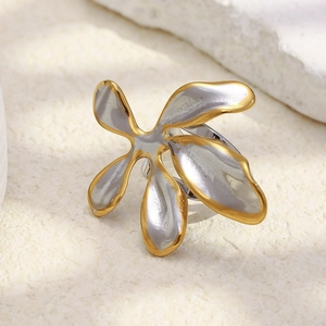 Detalle macro de un anillo de flor artístico con acabado plateado y bordes dorados