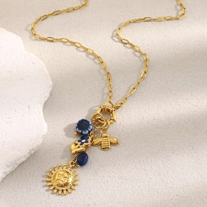 Detalle del collar de clip chapado en oro de 18K con dijes de sol abeja y piedra azul