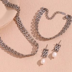 Makroaufnahme von Silberschmuck-Set mit 18K-Anhänger und weißen Perlenohrringen
