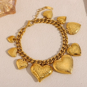 Détail macro du bracelet gourmette plaqué or 18 carats avec plusieurs breloques en cœur