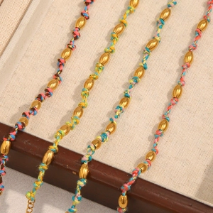 Détail de bracelets tressés colorés avec perles en forme de barillet plaqué or 18 carats