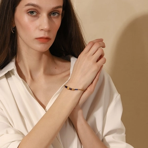 Detail view of 18K gold plated chain bracelet with natural blue lapis beads on wrist