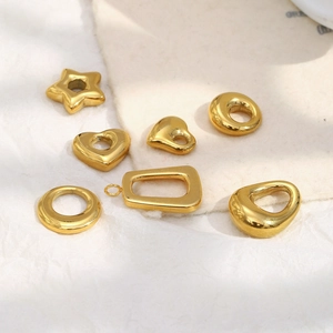 Detailed view of polished 18K gold plated geometric pendants in heart and star shapes