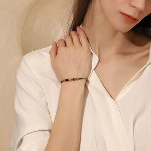 Close-up of vintage 18K gold plated bracelet with dark blue natural stone beads on wrist