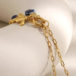 Elegante collar bañado en oro de 18 quilates con colgante de abeja y cuenta floral azul