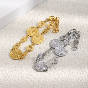 Détail des bracelets à maillons circulaires à texture spirale dorée et argentée avec fermoir