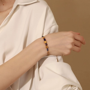 Minimalist 18K gold plated beaded bracelet with blue stones and a gold smiley face charm