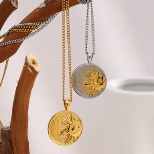 Vue détaillée des pendentifs soleil plaqués or 18K suspendus sur une branche