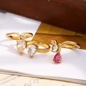 Dettaglio di eleganti anelli placcati oro con zirconi a forma di pera bianchi e rosa