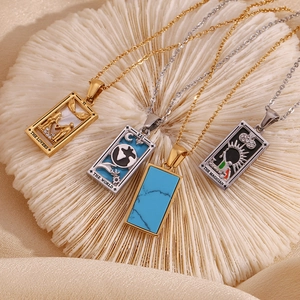 Makroaufnahme der 18K vergoldeten Tarot-Anhänger mit Motiven von Die Liebenden und Die Welt