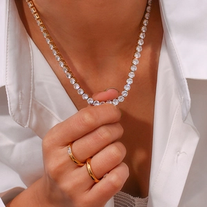 Gros plan d'un collier tennis en zircon de 2mm et de bagues portés par un mannequin