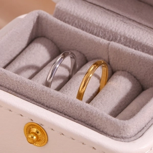 Polished silver and 18K gold plated stainless steel rings in a soft velvet jewelry box