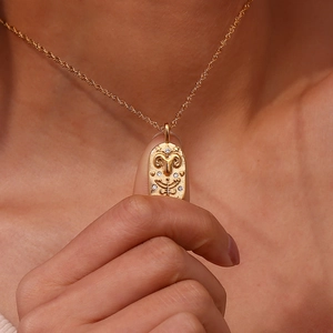 Macro detail of Aries zodiac oval pendant in gold finish with sparkling zircon stones