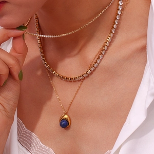 Détail d'un ensemble de colliers dorés avec pendentif en lapis-lazuli et zircons
