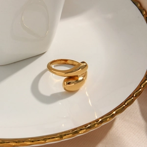 Detailopname van gouden druppelring met een gepolijste organische gebogen afwerking
