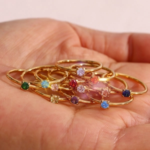 Detail of 18K gold plated thin rings with colorful round zircon stones in claw setting