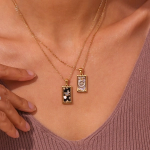 Close-up of The Sun and The World tarot card pendant necklaces on a female model