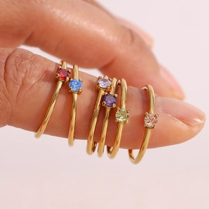 Detail of 18K gold plated stackable rings with colorful round-cut birthstones