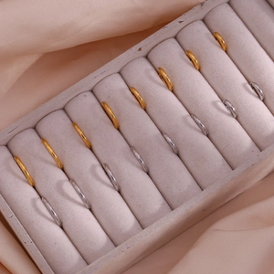Polished gold and silver stainless steel hoop earrings set displayed in a jewelry box