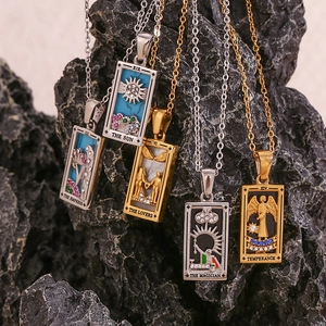 Detail von Tarot-Anhängern wie Die Sonne und Die Liebenden auf rustikalem Stein