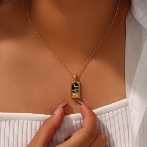Detail of Knight of Cups tarot necklace with black enamel and gold moon star pendant