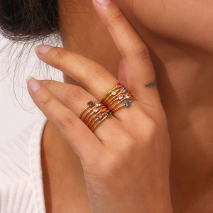 Close-up of gold-plated birthstone rings with multi-colored stones for stylish stacking