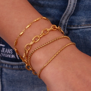 Macro shot of 18K gold plated stainless steel box and link chain bracelets set on wrist