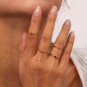 Macro shot of 18K gold plated minimalist stacking rings featuring vibrant round gemstones