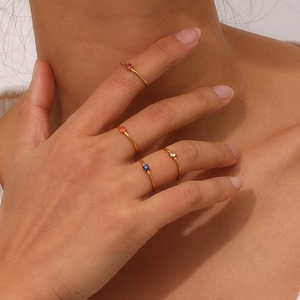 Macro detail of minimalist 18K gold plated stainless steel rings with round gemstones