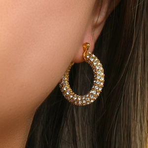 Dettaglio ravvicinato di orecchini a U placcati oro 18K con pavé di zirconi luccicanti