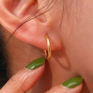 Detailed close-up of a small 18K gold plated stainless steel hoop earring worn on the ear