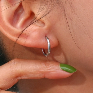 Close-up of classic minimalist silver hoop earring with polished finish on the ear