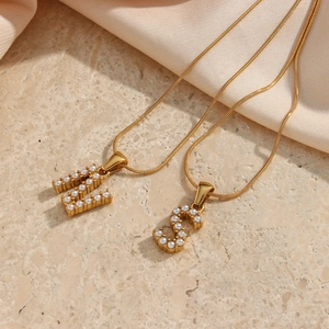 Λεπτομέρεια από χρυσή αλυσίδα φίδι 18K με μενταγιόν γράμματα H και S με πέρλες