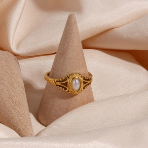 Detailed view of freshwater pearl gold floral ring on wooden display stand