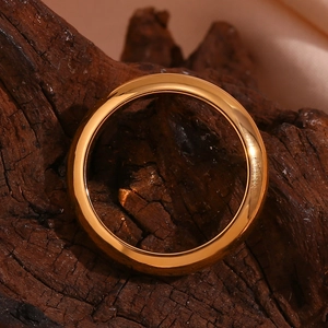 Detailed macro view of a chunky 18K gold plated stainless steel band on rustic wood