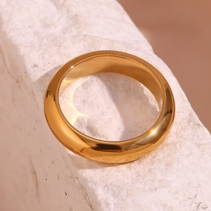 Macro shot of 18K gold plated thick minimalist band ring on stone texture background
