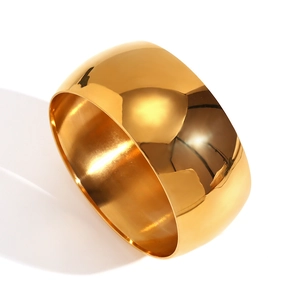 Polished wide chunky 18K gold plated stainless steel cuff bracelet on white background