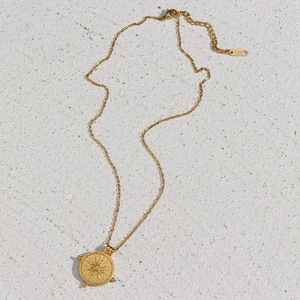 Détail du pendentif boussole solaire en acier plaqué or 18K avec fermoir mousqueton