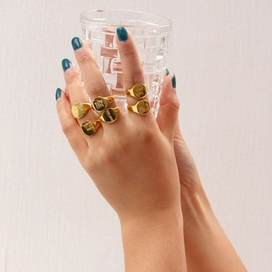 Primer plano de anillos de sello bañados en oro con frases grabadas en inglés