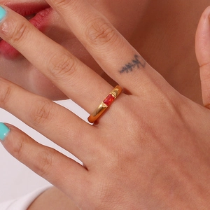 Primo piano di anello placcato oro 18K con zircone rosso rettangolare sulla mano